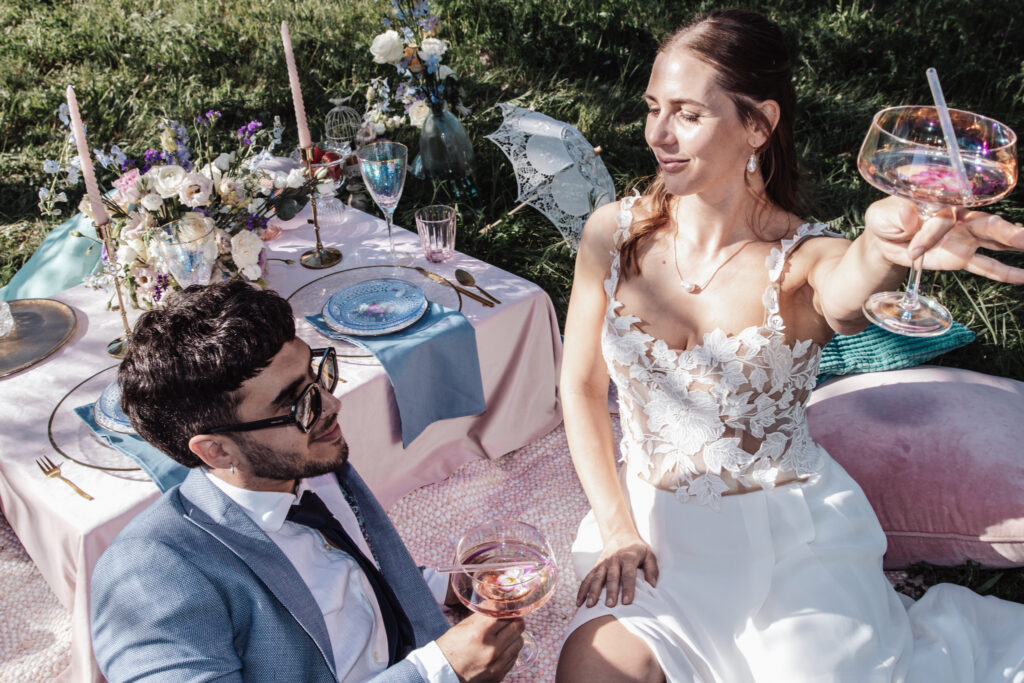 Hochzeitspaar ausgelassen Picknick. Champagner und Blumendeko